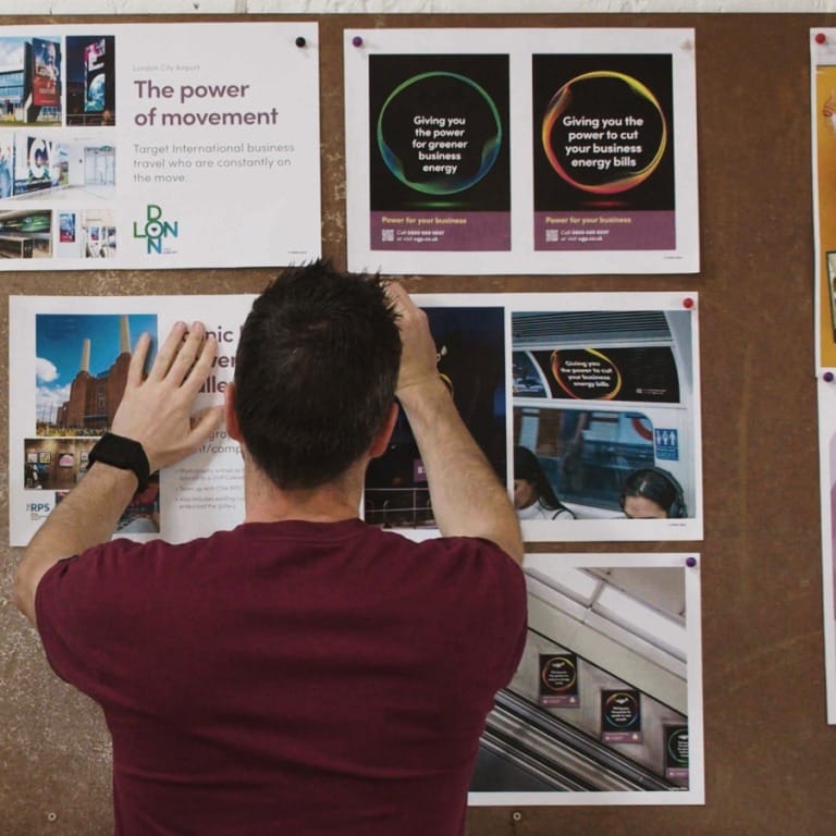 Creative Director pinning designs to wall